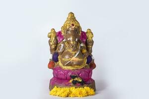The Hindu Festival Ganesh Chaturthi is celebrated by placing flowers on a beautiful Ganesh statue made of clay on a white background. photo