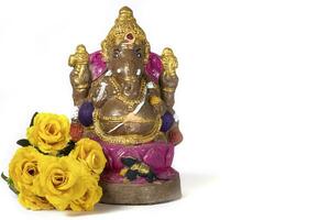 Vinayaka Chaturthi - Ganesh statue made of clay with flowers on white background. photo