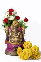 Happy Ganesh Chaturthi Festival - Beautiful Ganesh statue made of clay with flowers on white background. photo