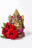 Ganesh statue made of clay is also a rose flower on white background. photo