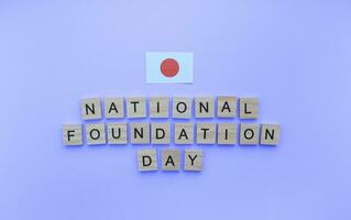 February 11, National Foundation Day, flag of Japan, minimalistic banner with wooden letters on a blue background photo