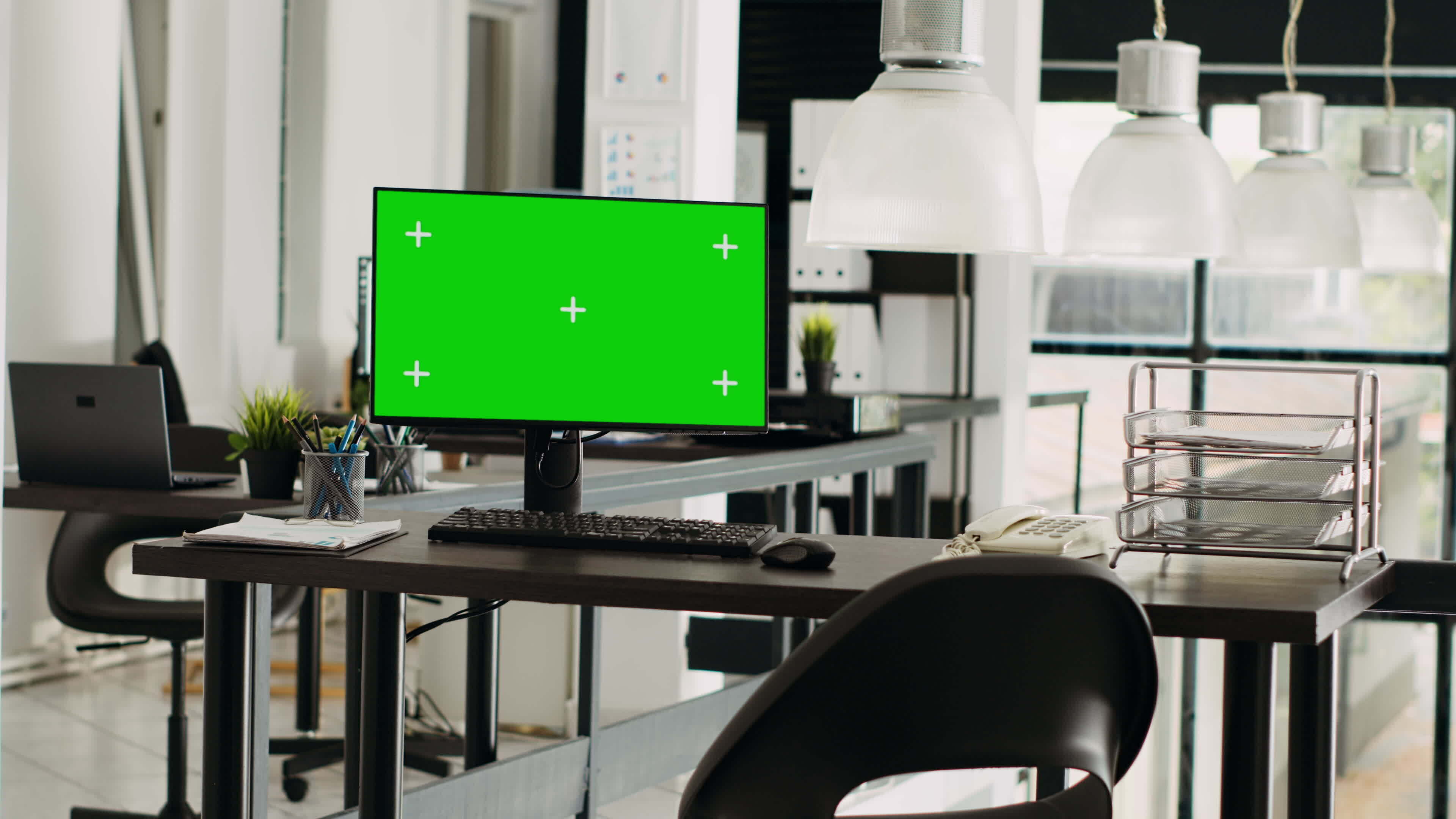 Office desktop pc running greenscreen at empty business workstation