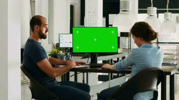 Startup team looking at pc with greenscreen, small business office desk. Company workers analyzing isolated copyspace template, doing teamwork for income development, chromakey on display. video