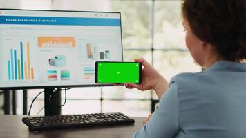 bedrijf specialist shows groene scherm Aan smartphone software Scherm, op zoek Bij geïsoleerd Chroma sleutel sjabloon en werken Aan computer Bij bureau. gebruik makend van blanco mockup en afwerking agentschap activiteiten. video