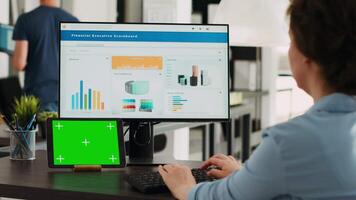 zakenvrouw looks Bij groene scherm en werken Aan afzet voorraad, analyseren geïsoleerd Chroma sleutel lay-out en klein agentschap omzet netwerk. specialist Bij werkstation met tablet en pc. video