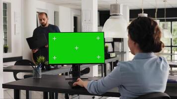 analista controlli schermo verde del desktop su pc, seduta nel coworking spazio a agenzia ufficio. azienda lavoratore l'esame computer tenere sotto controllo in esecuzione vuoto copyspace con modello schermo. palmare sparo. video