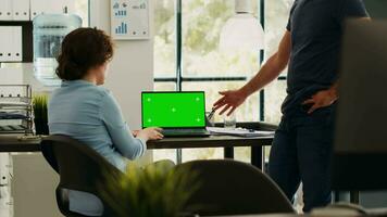 Business team analyzing greenscreen on laptop display, brainstorming new ideas and working on startup operations. Coworkers discussing about partnership, blank copyspace template. video