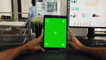 pov di uomo d'affari Tenere tavoletta con schermo verde modello, guardare a chiave cromatica Schermo e seduta coworking spazio scrivania. persona l'esame isolato modello copyspace su aggeggio schermo. video