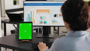chef klockor läsplatta med grönskärm medan hon löser företag operationer i kontor, ser på enhet löpning tom attrapp visa. specialist utseende på Chromakey programvara. handhållen skott. video
