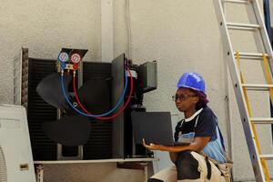 mecánico mirando en línea para nuevo motor después hallazgo roto interno parte durante aire acondicionador chequeo. africano americano reparador comprobación componentes valores antes de reemplazando roto uno foto