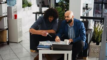 Research team verifying reports for business development plan, reading archived documents with analytics in office. Coworkers reviewing notes in open space, management expertise. photo