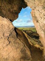 a view of the landscape through a cave photo