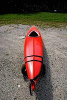 a red kayak sitting on the ground photo