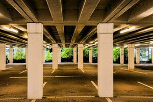 an empty parking lot with columns and trees photo