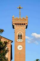 un reloj torre con un cruzar en parte superior foto