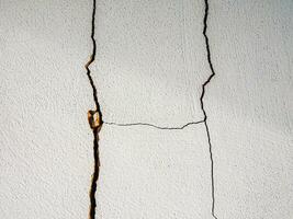 Cracks in the cement wall White cement of buildings damaged by earthquakes photo