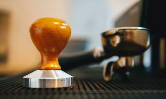 Equipment in a coffee shop of barista coffee tool coffee tamper and  a portafilter on counter in a cafe photo
