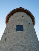 High tower of the Pskov Kremlin against the blue sky. Bottom view. photo