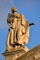 statue of person on the roof of the cathedral photo