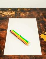 a pencil and paper on a wooden table photo