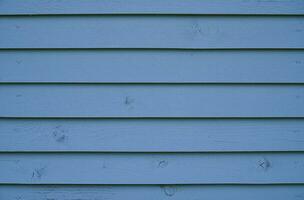 Blue wood background. The wall of the house made of blue wooden boards. photo