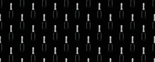 Seamless pattern of black wine bottles with a silver top on a black background. photo