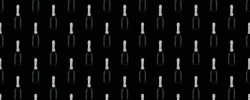 Seamless pattern of black wine bottles with a silver top on a black background. photo