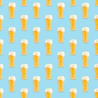 Seamless pattern of large beer glass full of beer with foam on blue background. photo