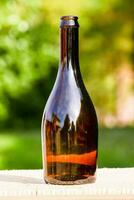 a brown bottle sitting on a wooden table photo