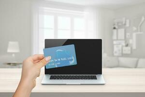 Hand holding credit card against laptop backdrop. Symbolizing online payment convenience. Seamless e-commerce transaction. Secure digital shopping experience with a credit card photo