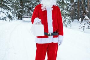 santa claus al aire libre en invierno y nieve entregando bolsas de papel con regalos artesanales, entrega de alimentos. compras, reciclaje de envases, hecho a mano, entrega para navidad y año nuevo foto