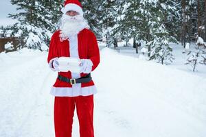 contenedores de servicio de entrega de alimentos en manos de santa claus al aire libre en la nieve. promoción de nochebuena. Pedido caliente listo para usar, caja de plástico desechable. catering de vacaciones de año nuevo. copia espacio, maqueta foto