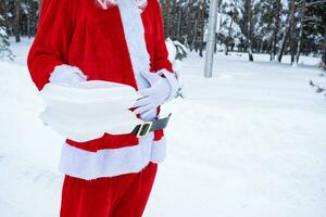 comida entrega Servicio contenedores en manos de bien alimentado Papa Noel al aire libre en nieve. Navidad víspera promoción. confeccionado caliente orden, desechable el plastico caja. nuevo año Días festivos abastecimiento. Copiar espacio, burlarse de arriba foto