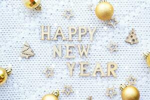 Happy New Year wooden letters on cozy festive white knitted background with sequins, stars, lights of garlands. Greetings, postcard. Calendar, cover photo