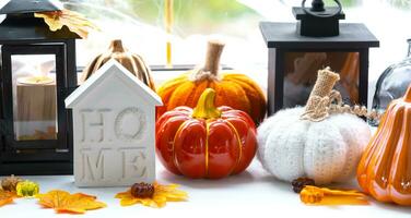 Cozy autumn decor on the windowsill with pumpkins, autumn leaves, a house and keys - autumn mood, Halloween, housing, relocation, mortgage, insurance. photo