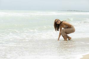 hermosa asiático mujer relajante con felicidad en vacaciones mar playa foto