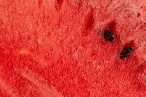 Juicy tasty watermelon with red texture and bone, close-up. Summer wallpaper photo