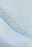 Fashion denim fabric, close-up. Light blue jeans photo