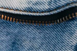 Vintage jeans with a zipper, close-up. Fashion blue denim fabric texture photo