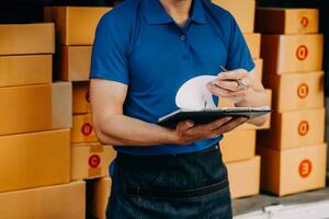 Asian delivery man in cargo van checking boxes. photo