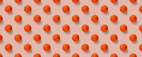 Fruit pattern of fresh oranges on pink background. Pop art design, creative summer concept. photo