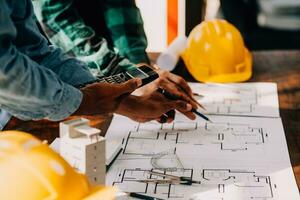 Construction and structure concept of engineer working drawing on blueprint meeting for project working with partner on model building and engineering tools in working site, construction concept. photo