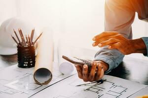 Construction and structure concept of engineer working drawing on blueprint meeting for project working with partner on model building and engineering tools in working site, construction concept. photo