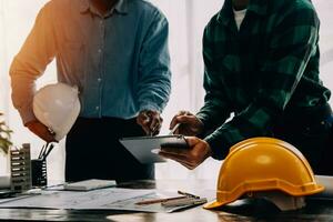 Construction and structure concept of engineer working drawing on blueprint meeting for project working with partner on model building and engineering tools in working site, construction concept. photo