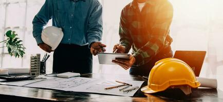 Construction and structure concept of engineer working drawing on blueprint meeting for project working with partner on model building and engineering tools in working site, construction concept. photo