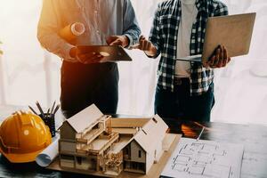 Construction and structure concept of engineer working drawing on blueprint meeting for project working with partner on model building and engineering tools in working site, construction concept. photo