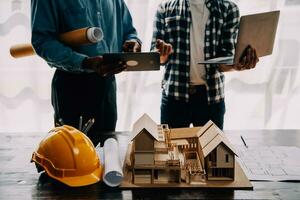 Construction and structure concept of engineer working drawing on blueprint meeting for project working with partner on model building and engineering tools in working site, construction concept. photo