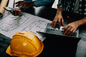 Construction and structure concept of engineer working drawing on blueprint meeting for project working with partner on model building and engineering tools in working site, construction concept. photo