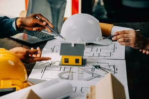 Construction and structure concept of engineer working drawing on blueprint meeting for project working with partner on model building and engineering tools in working site, construction concept. photo
