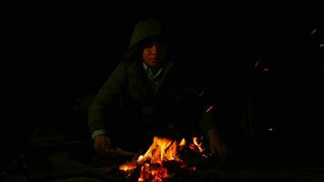 mettere la legna da ardere sul fuoco. il campeggio nel fuoco del campo brucia nella natura al buio. creare un fuoco. uso sicuro del fuoco nella foresta. video